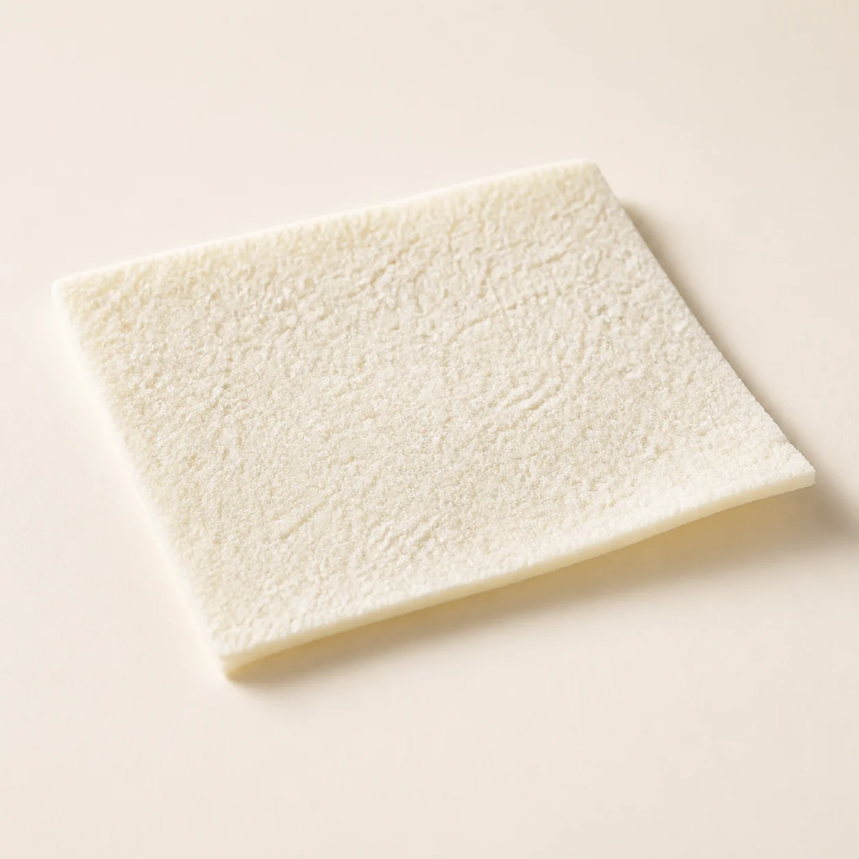 Pale rectangular dermal matrix sheet with a fine natural surface texture